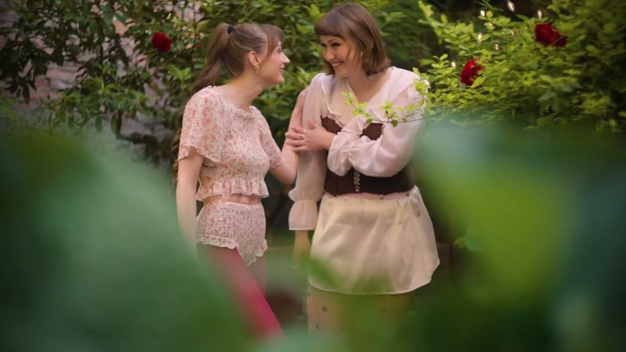 Still from the De Mode en Vogue commercial: two friends laughing in a rose garden