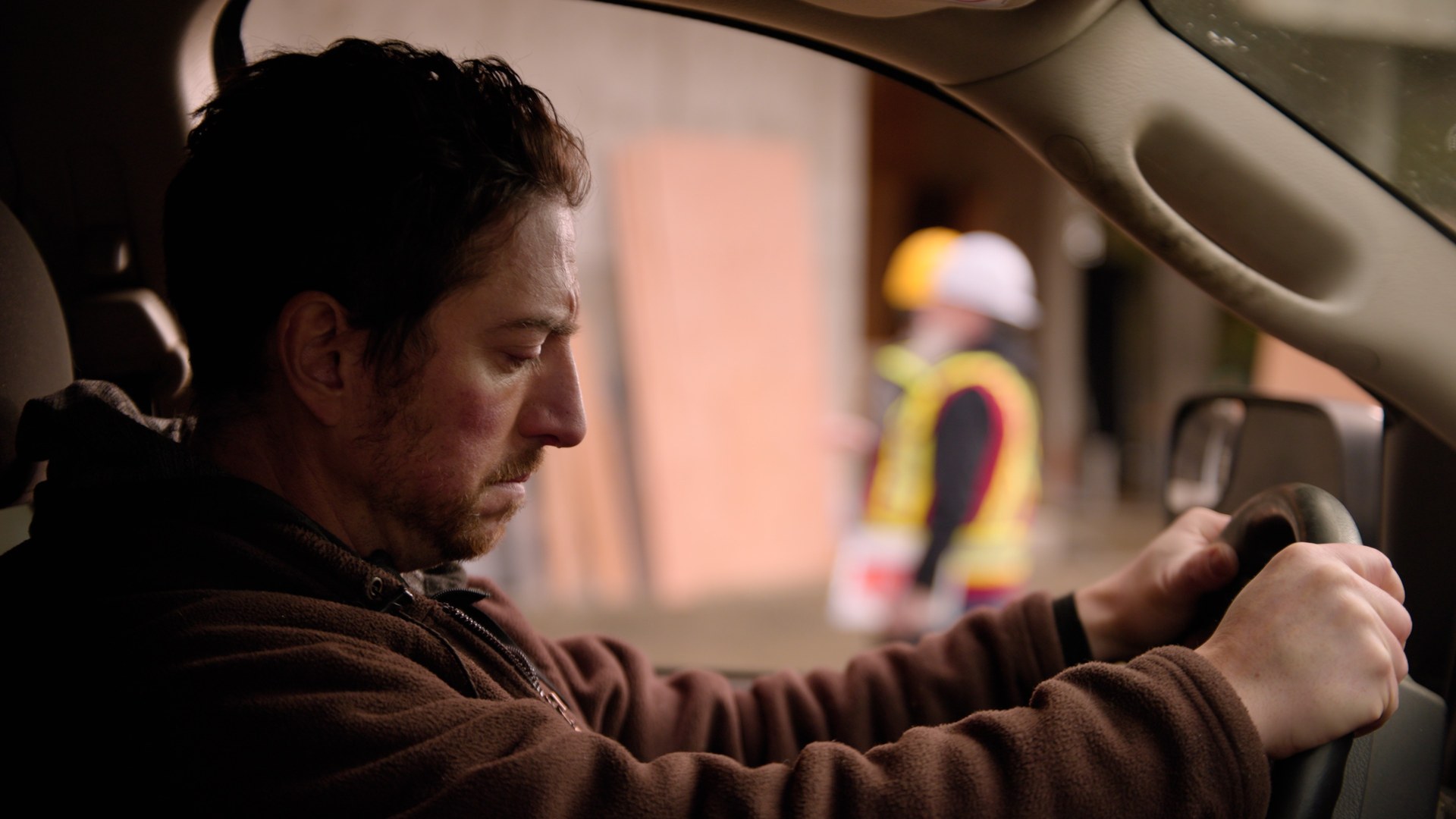 Opening scene of the Tailgate Toolkit commercial — a construction worker grips the steering wheel of his truck at a BC job site